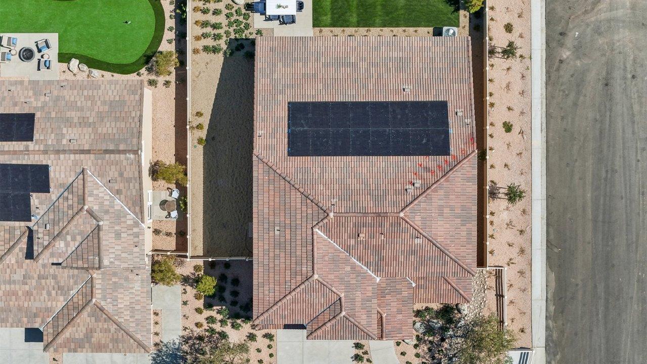 Aerial photo of home with solar panels and turf backyard