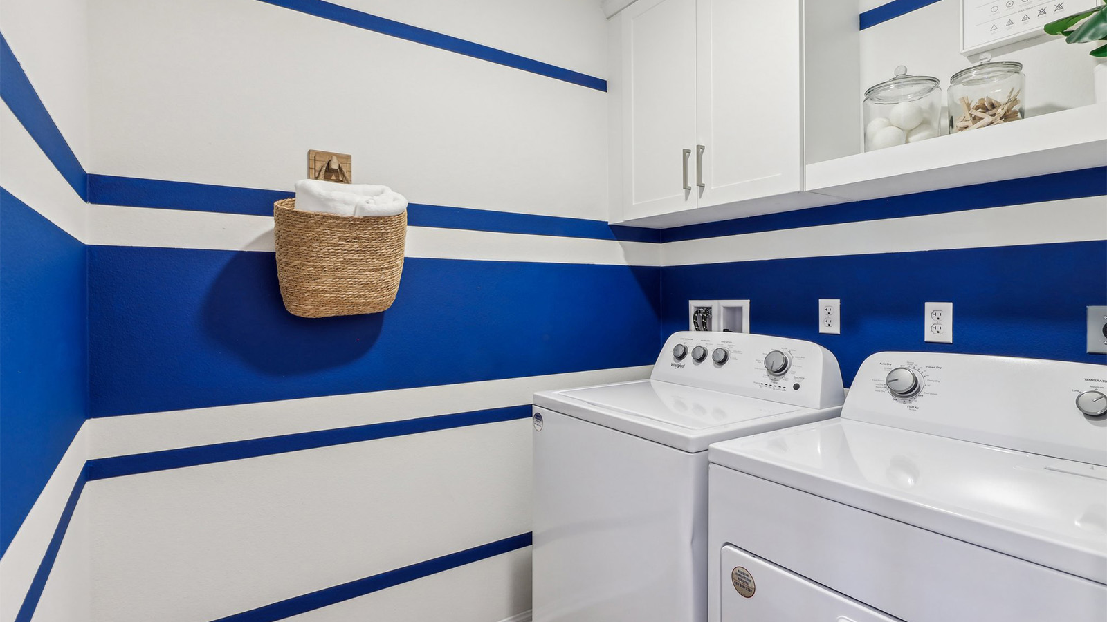Laundry room with upper cabinet and shelf and washer and dryer