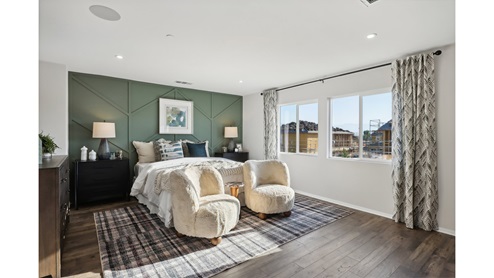 Spacious primary bedroom with king bed and laminate flooring
