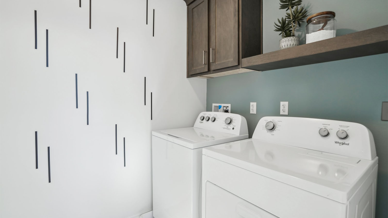 Laundry room with upper cabinet and shelf and washer and dryer