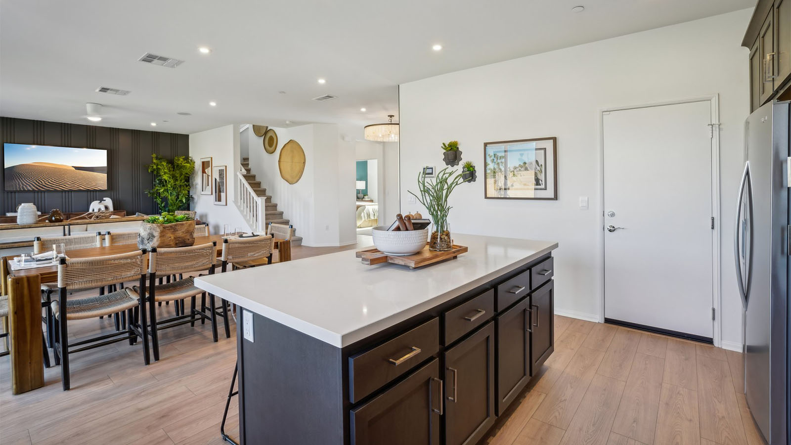 Open kitchen with dark cabinets quartz countertops and stainless steel appliances