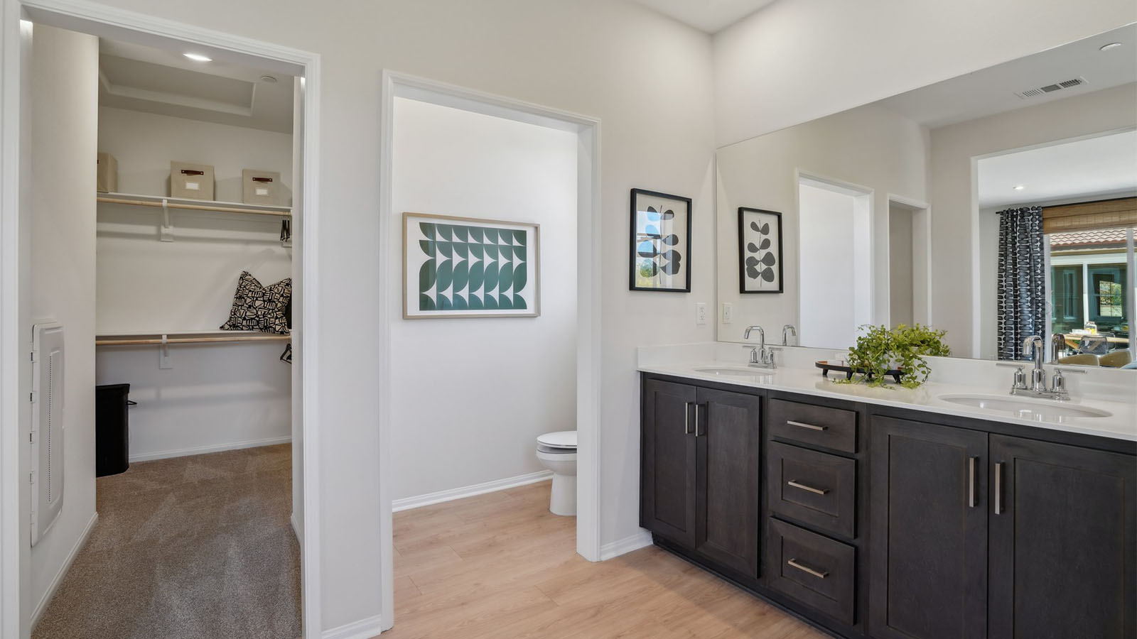 Primary bathroom with dual vanities and walk-in closet