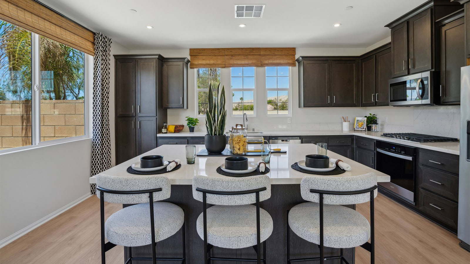 Modern kitchen with dark cabinets quartz countertops and stainless steel appliances