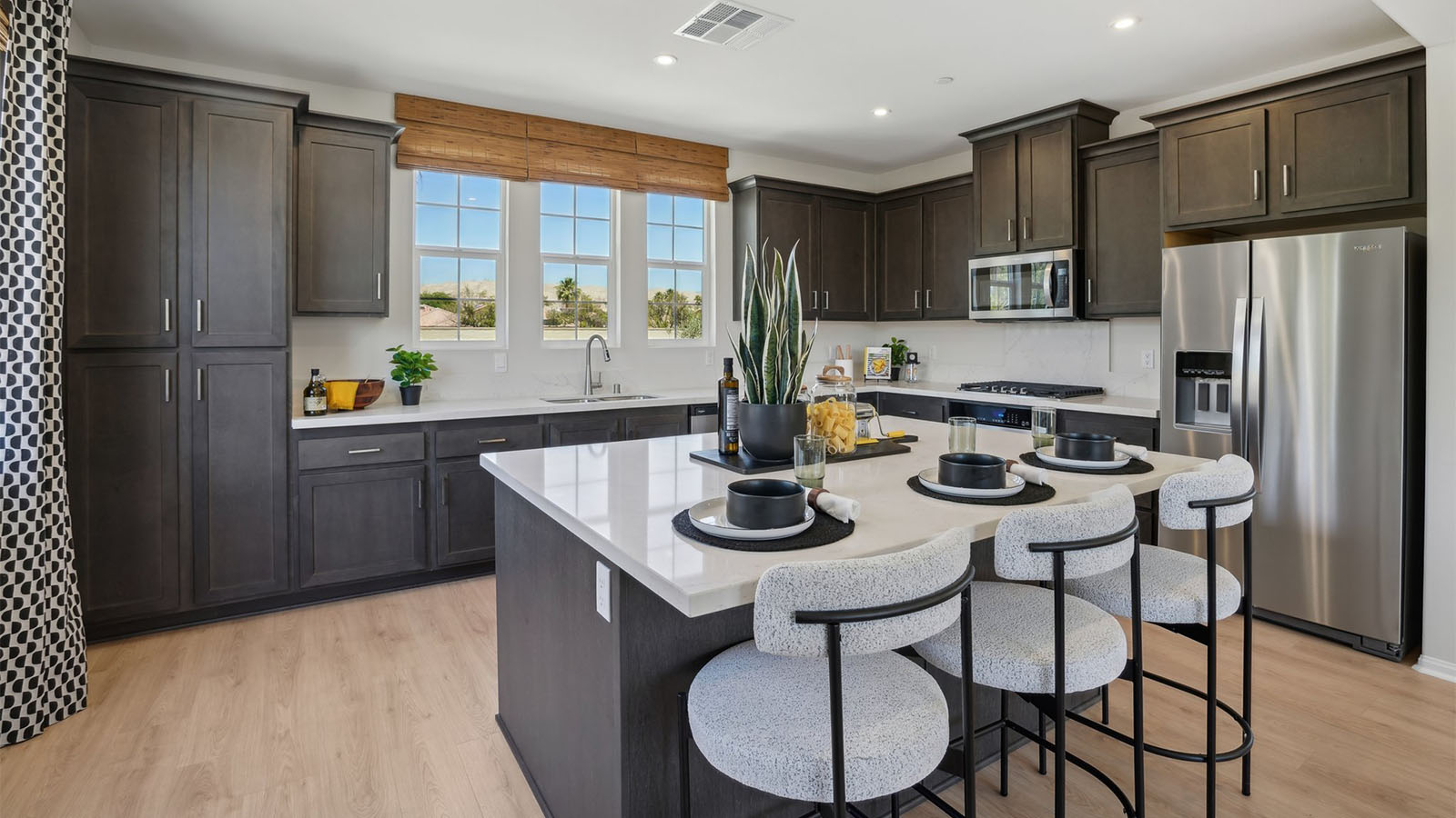 Modern kitchen with dark cabinets quartz countertops and stainless steel appliances
