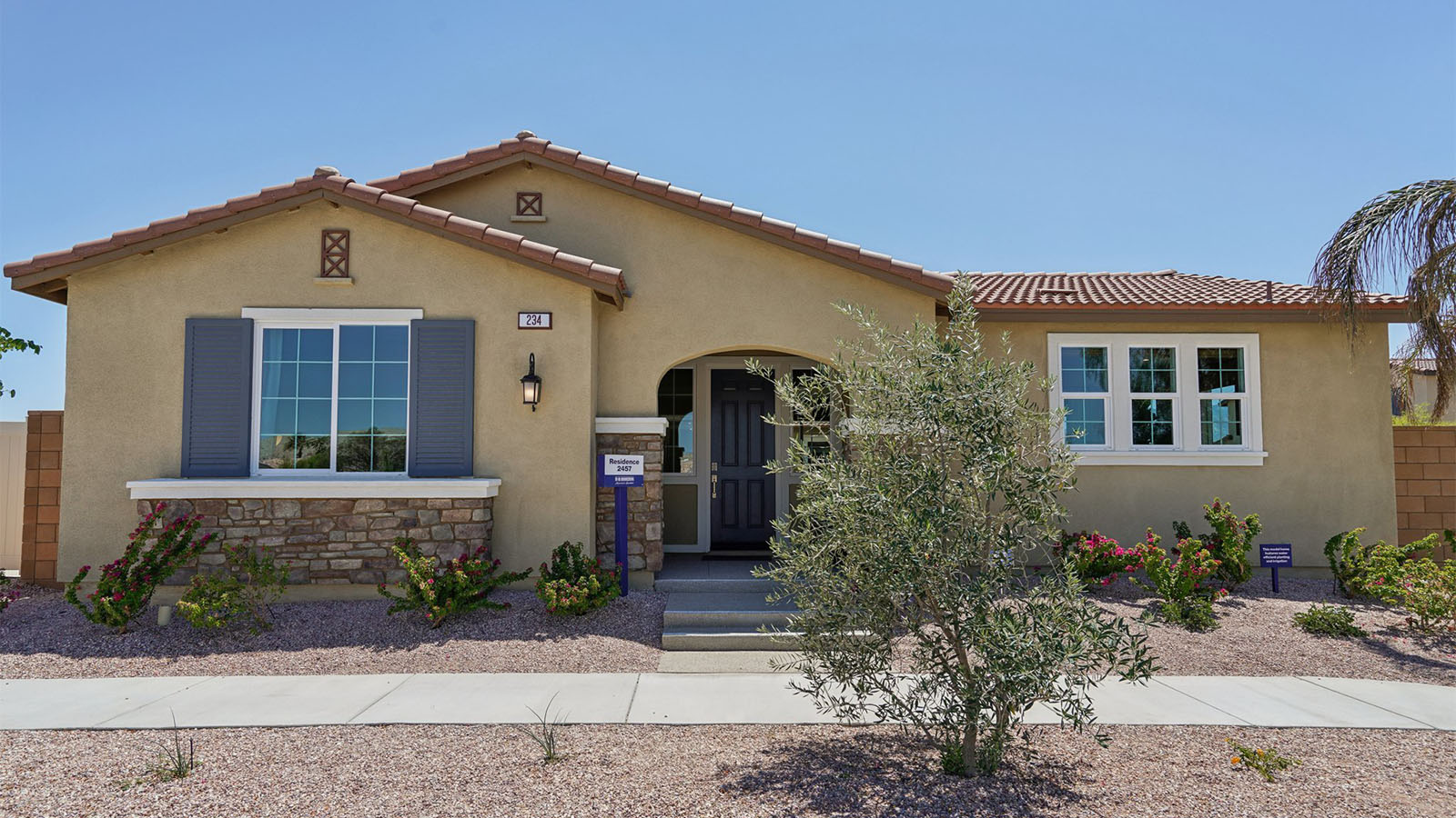 One-story Tuscan home with stone veneer and shutters
