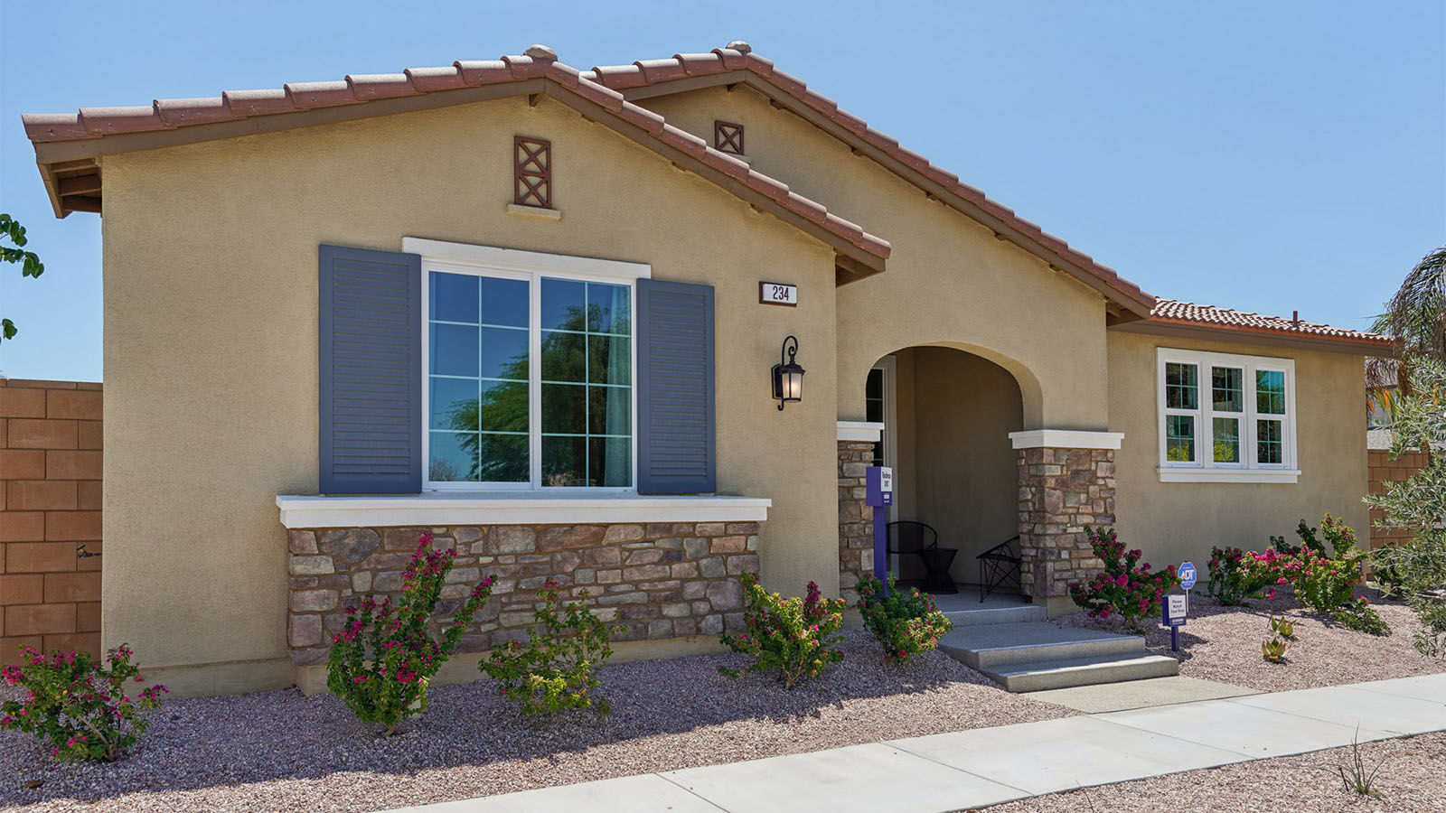 One-story Tuscan home with stone veneer and shutters
