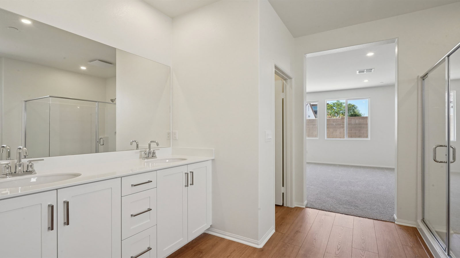 Primary bathroom with dual vanities and shower