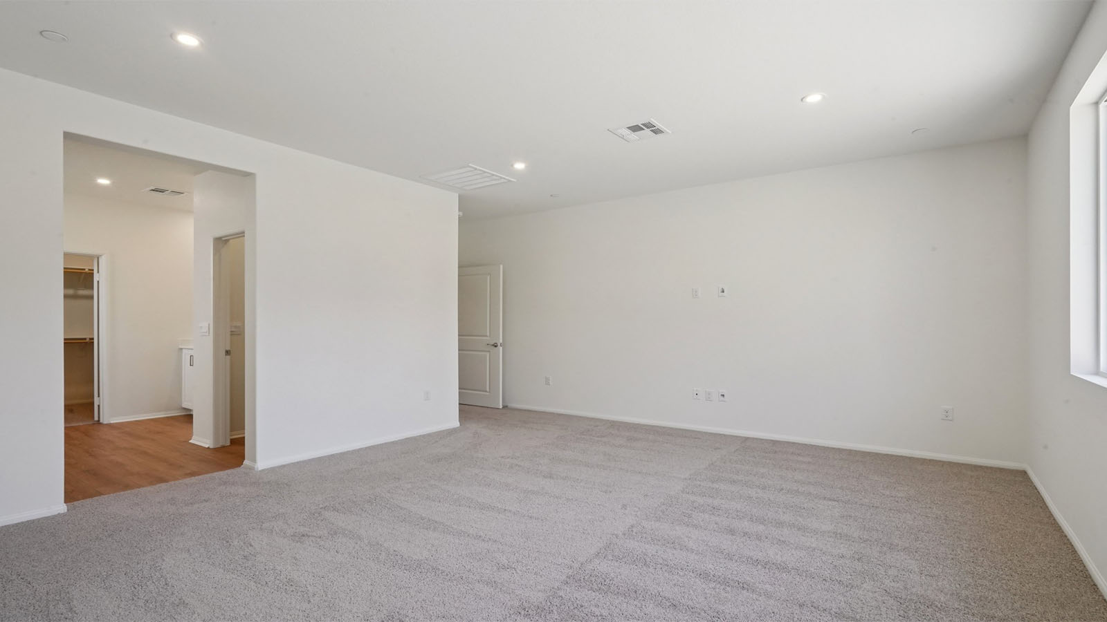 Primary bedroom with king bed and carpet