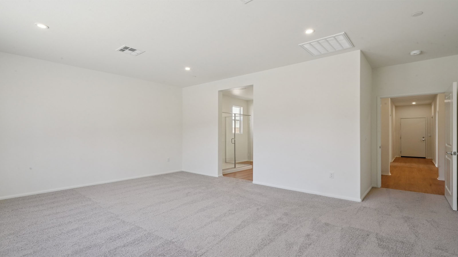 Primary bedroom with king bed and carpet