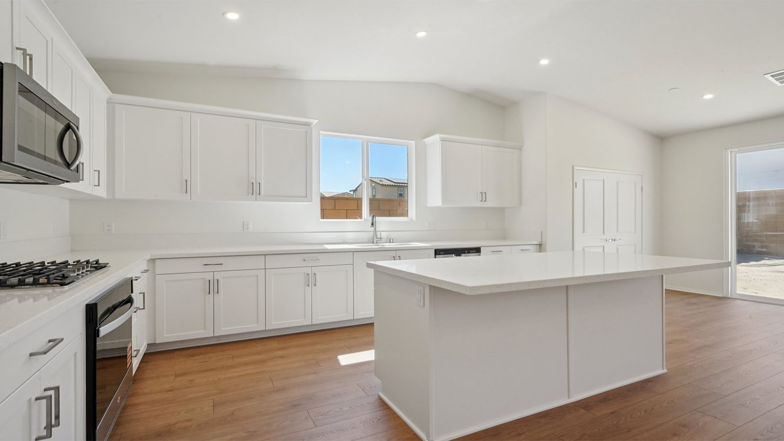 Modern kitchen with white cabinets quartz countertops and stainless steel appliances
