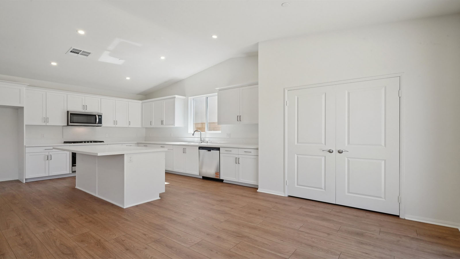 Open concept kitchen and dining area with vaulted ceiling