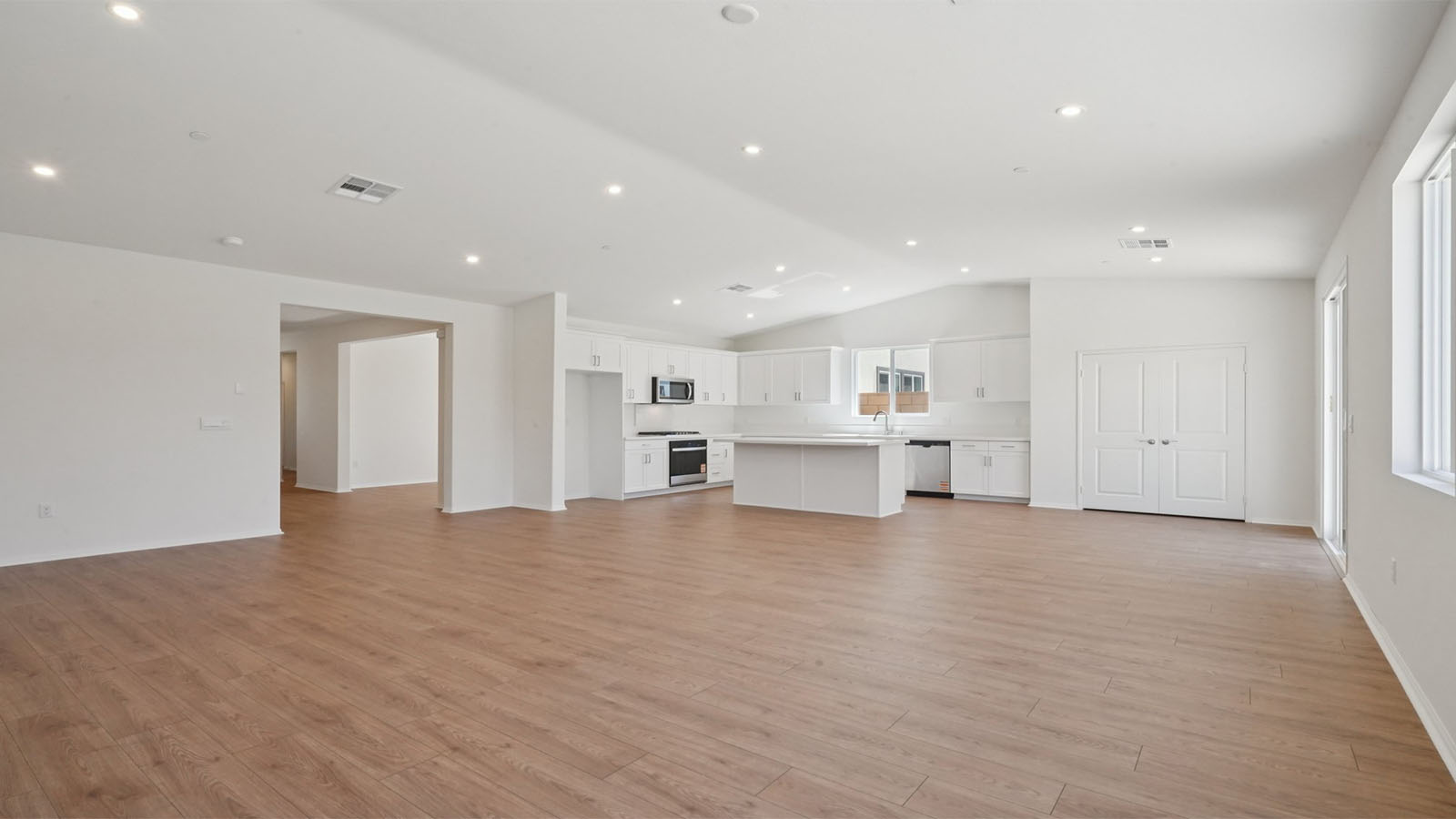 Spacious open-concept great room, dining room and kitchen with vaulted ceiling