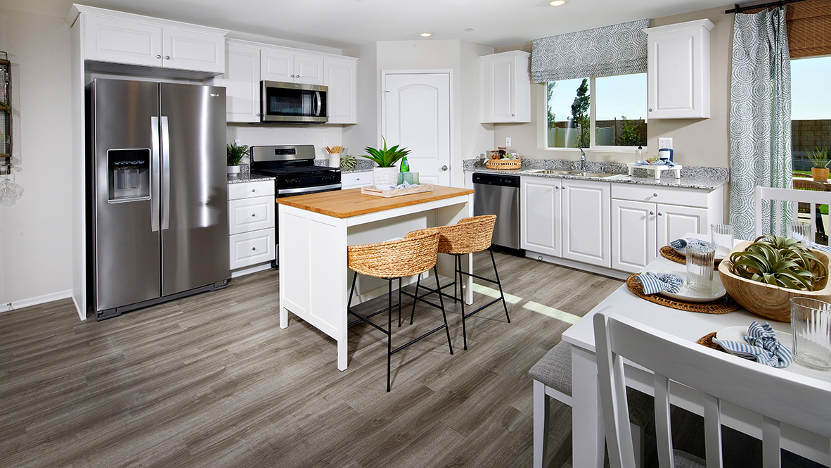 Open-concept kitchen area with stainless steel appliances and white cabinets