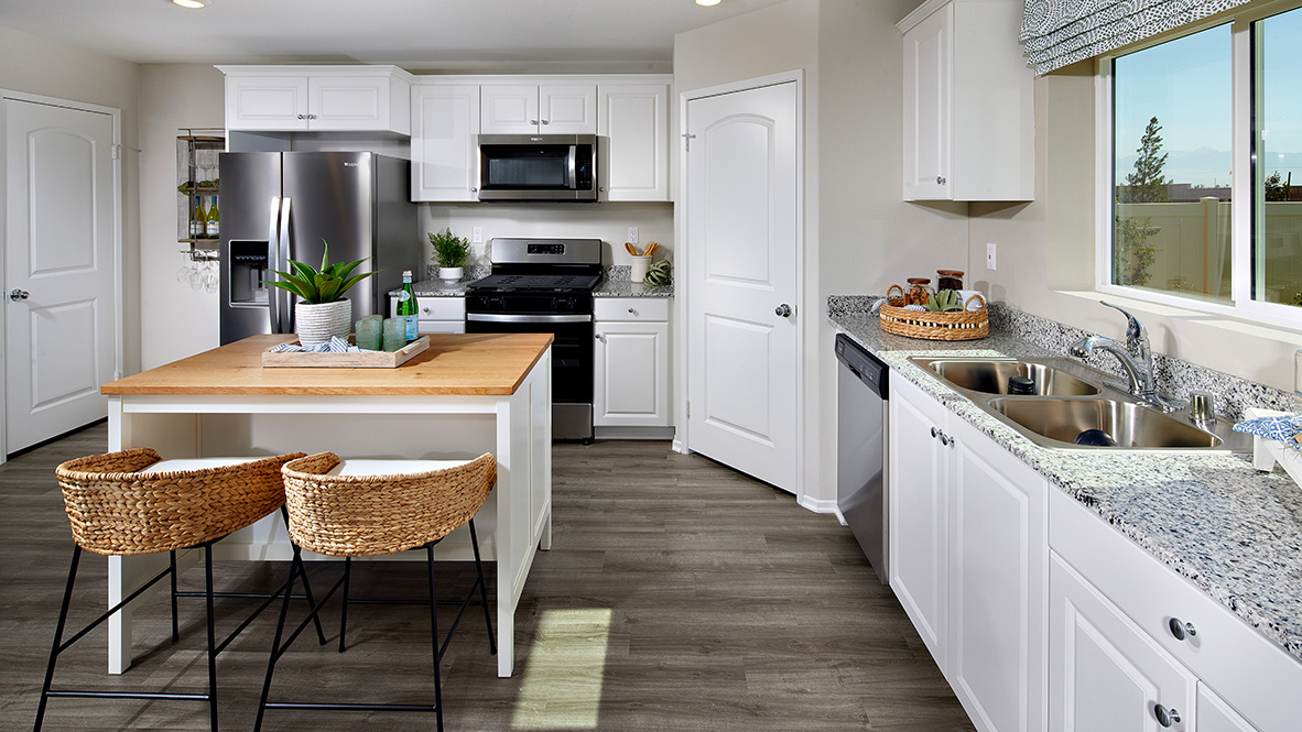Open-concept kitchen area with stainless steel appliances and white cabinets