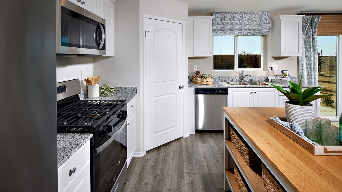 Open-concept kitchen area with stainless steel appliances and white cabinets