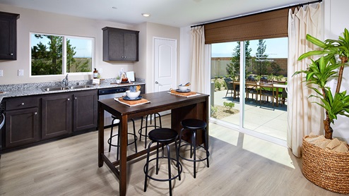 Open-concept kitchen area with dark cabinets and stainless steel appliances