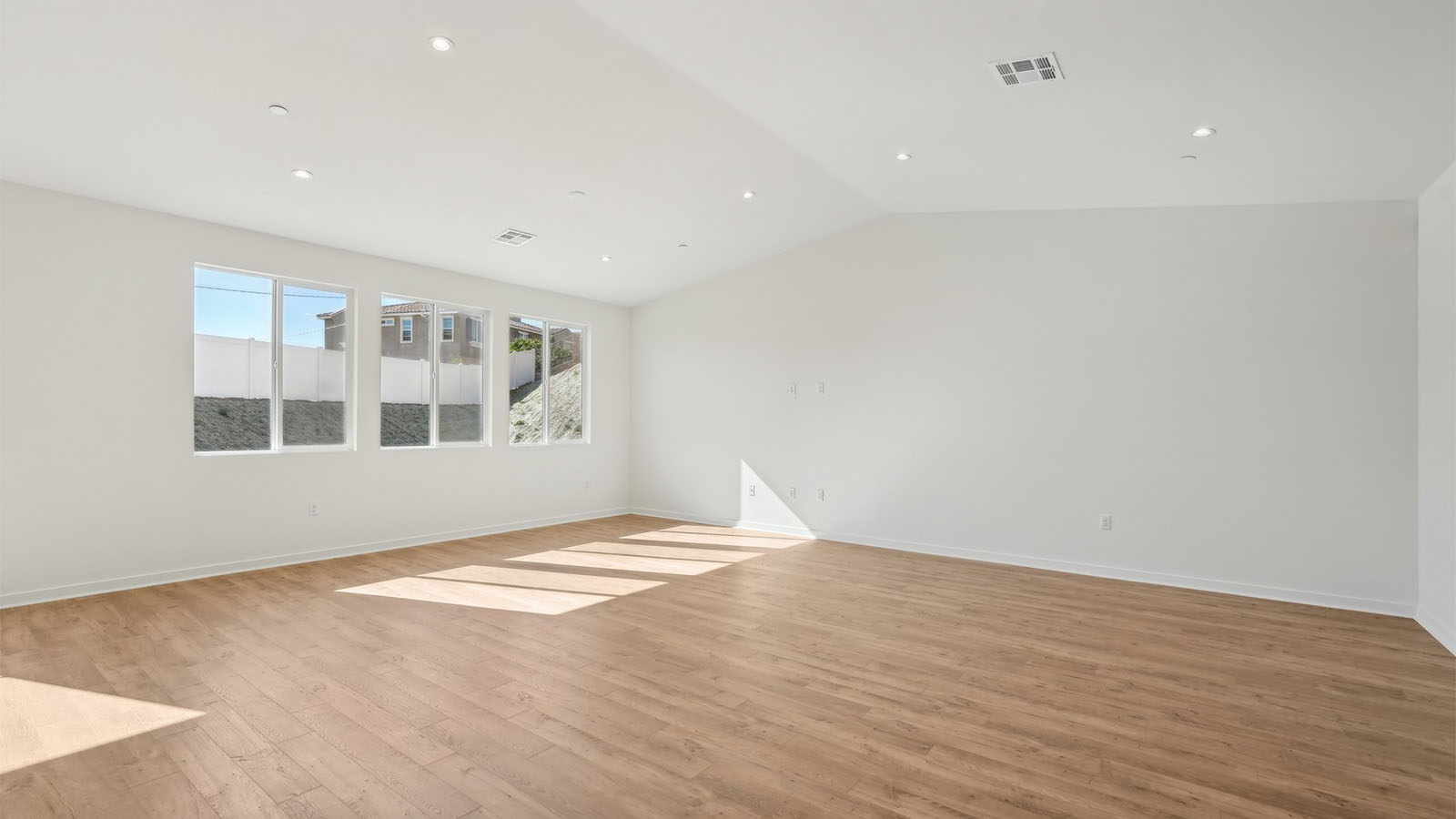 Spacious open-concept great room, dining room and kitchen with vaulted ceiling