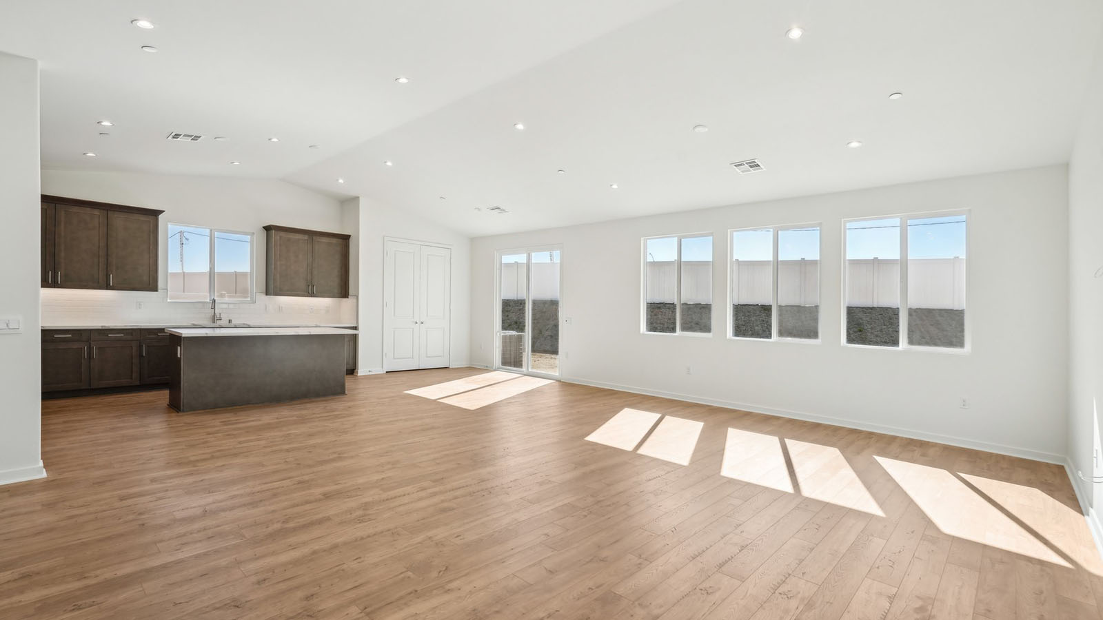 Spacious open-concept great room, dining room and kitchen with vaulted ceiling