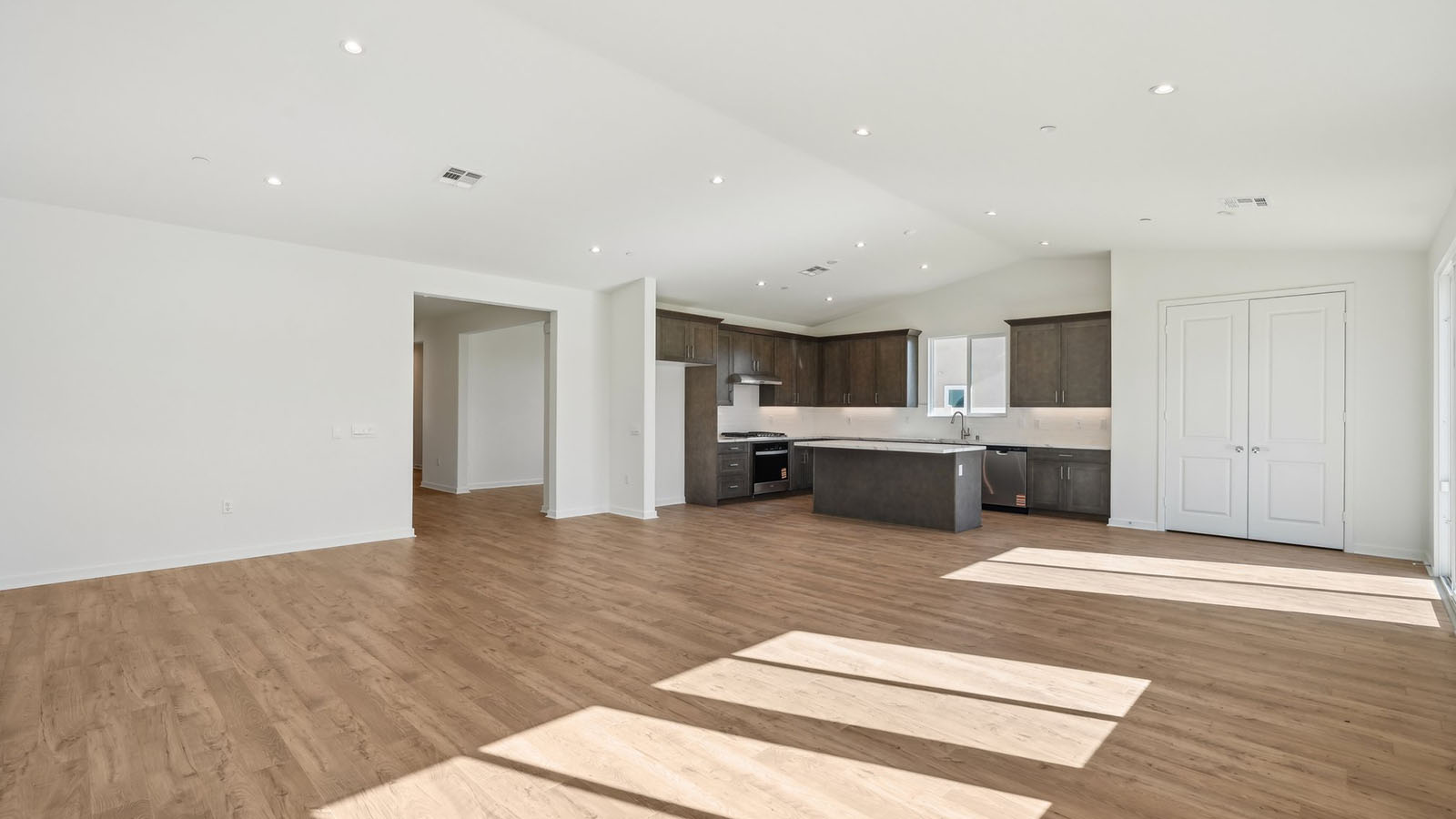 Spacious open-concept great room, dining room and kitchen with vaulted ceiling