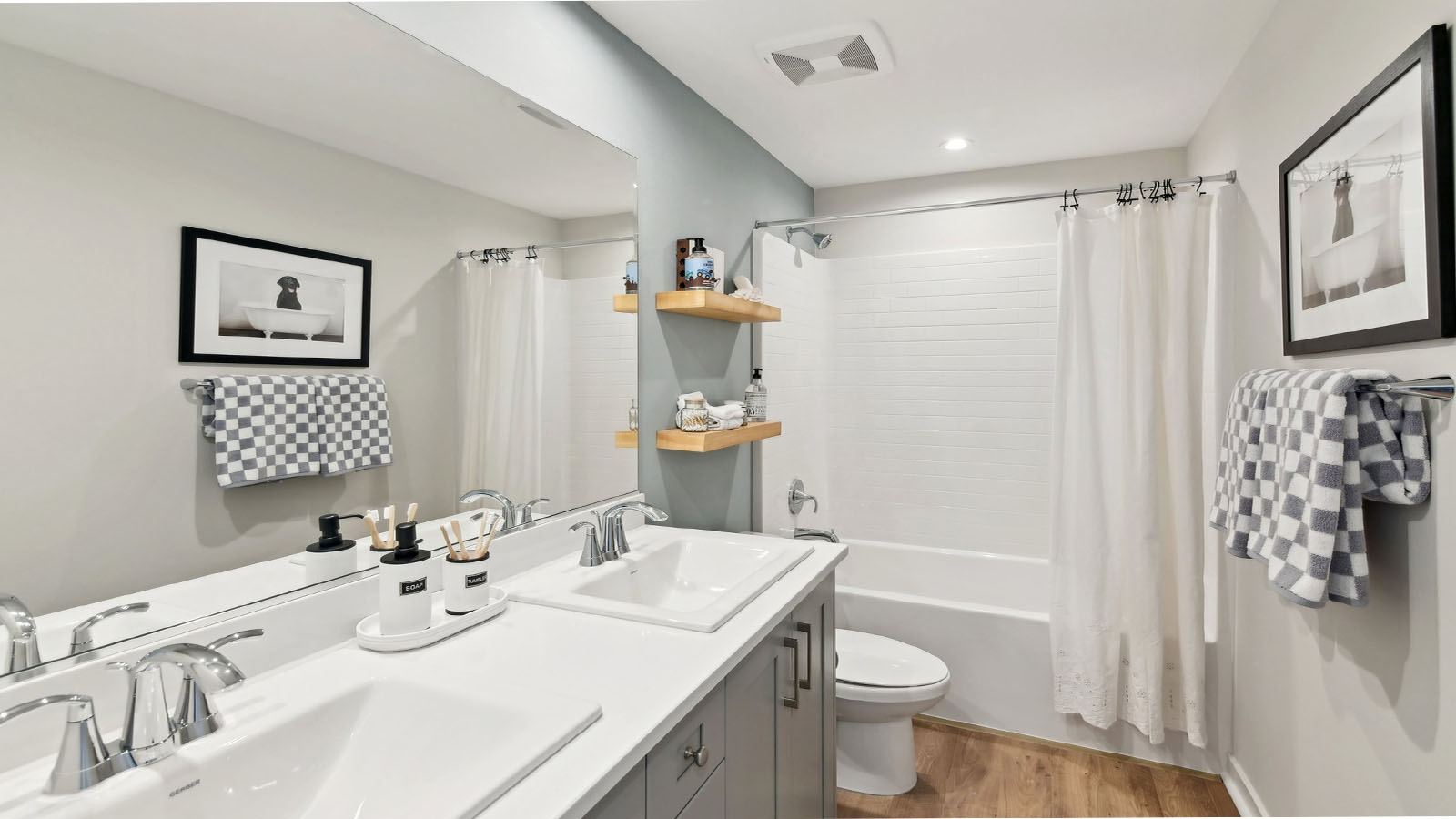 Secondary bathroom with dual vanities and tub shower combination
