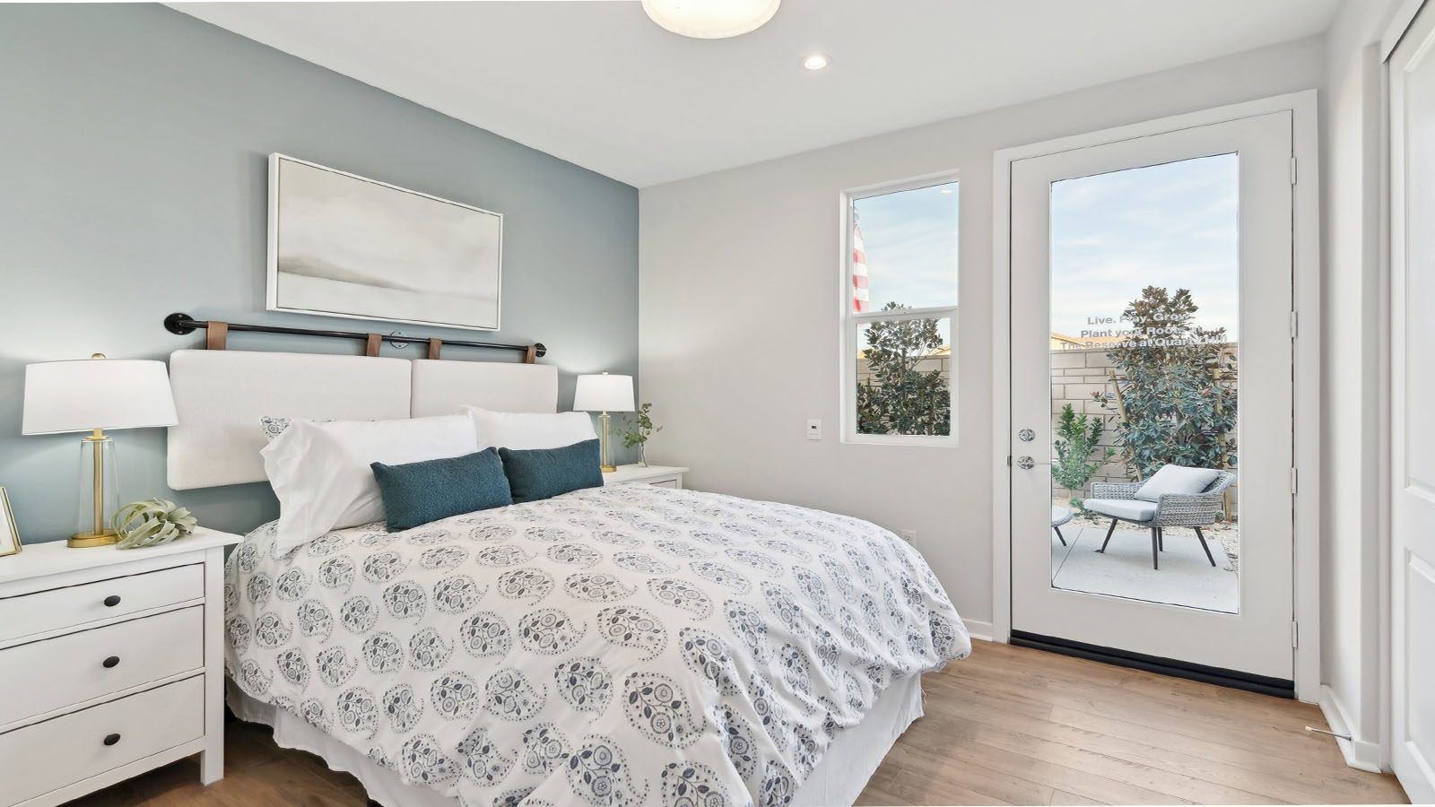 Multi-gen bedroom with full bed and French door leading to side yard