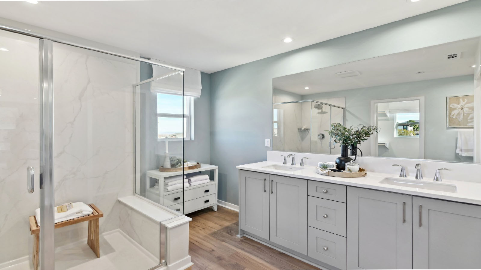 Primary bathroom with dual vanities and walk in shower