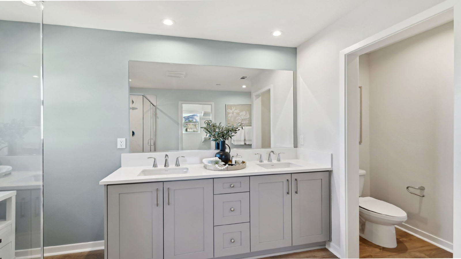 Primary bathroom with dual vanities and walk in shower
