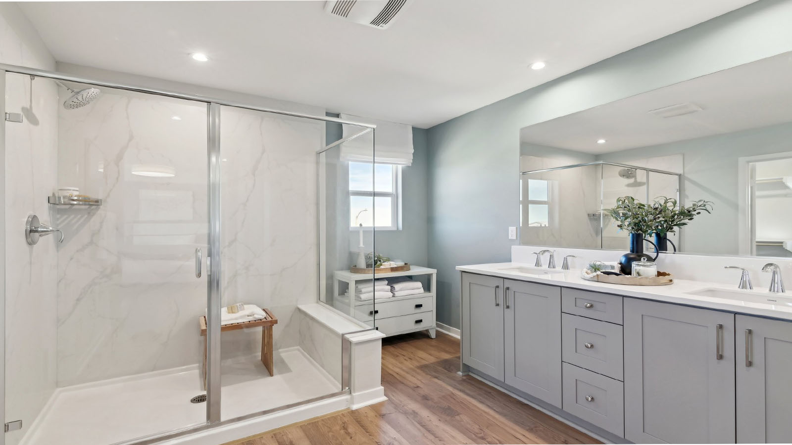 Primary bathroom with dual vanities and walk in shower