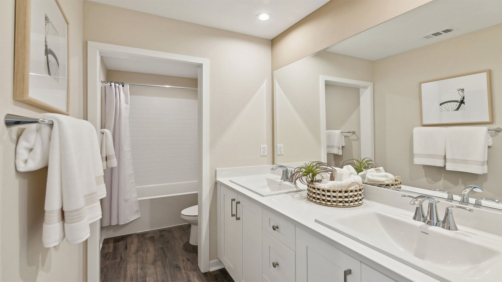 Secondary bathroom with dual vanities and tub shower combination