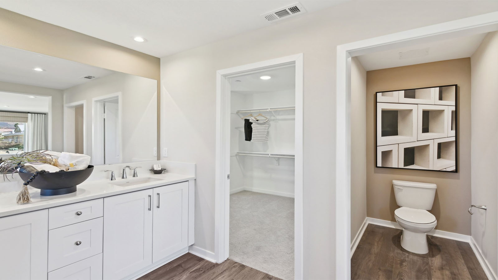 Primary bathroom with dual vanities and walk-in closet