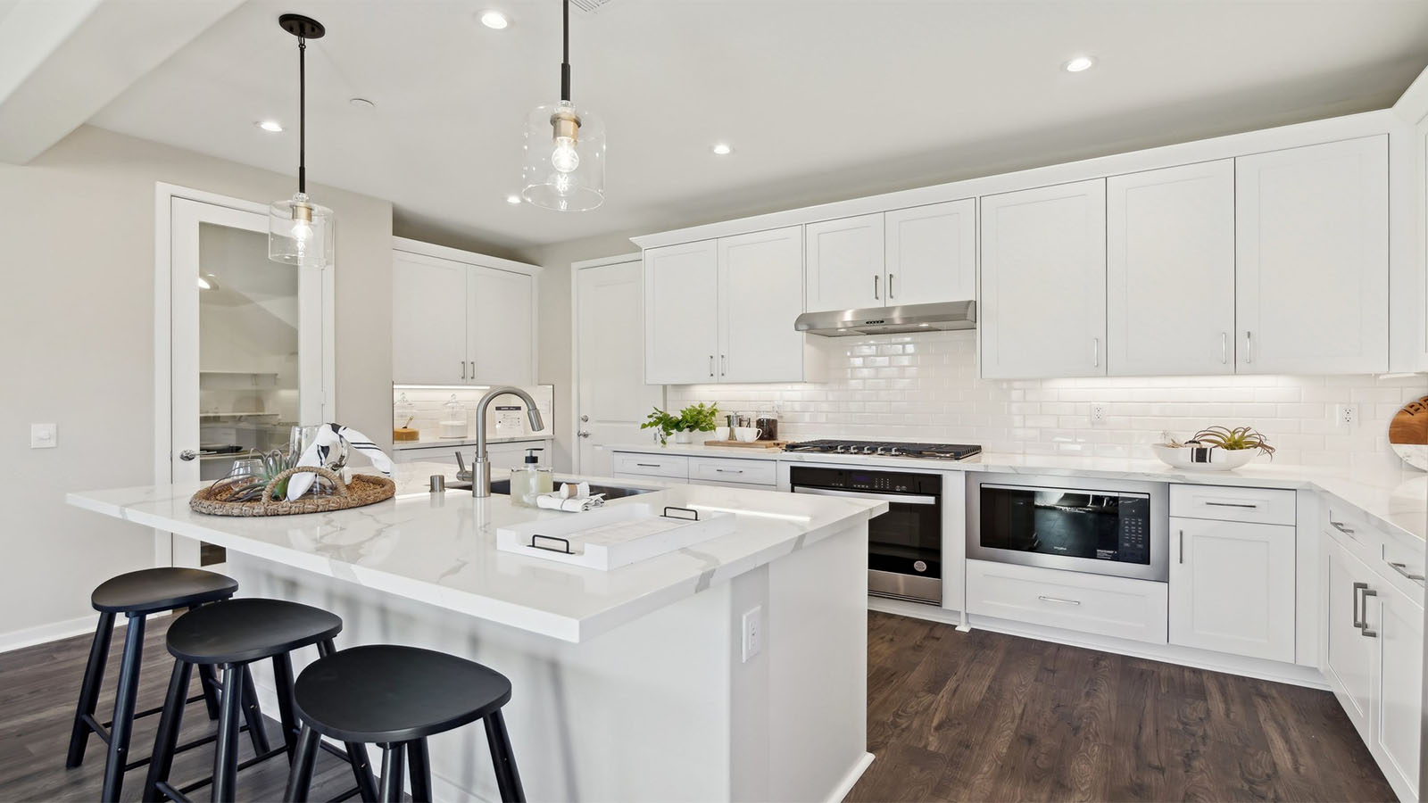 Modern kitchen with white cabinets quartz countertops and stainless steel appliances
