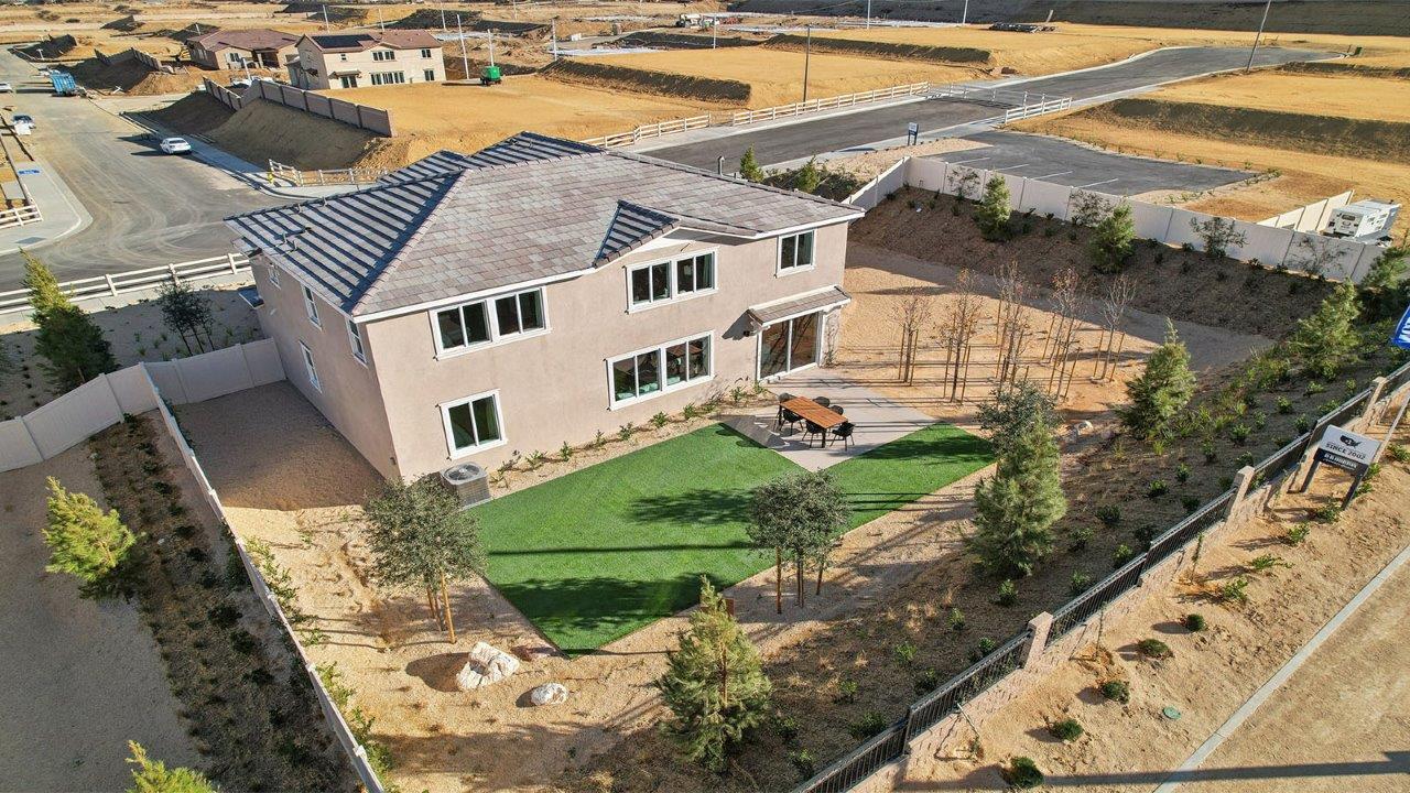 Aerial view of model home with Spacious backyard with turf and patio area