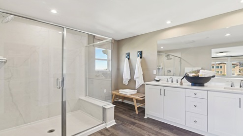 Primary bathroom with dual vanities and walk-in shower