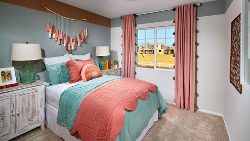 Augusta in Beaumont model home teen bedroom with pink pillows and blue bedding