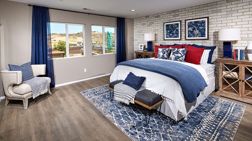 Augusta in Beaumont model home bedroom with laminate wood flooring and red pillows