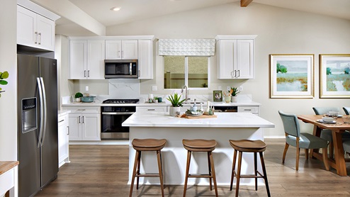 Kitchen peninsula with white cabinets, and stainless steel appliances
