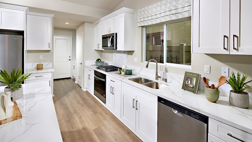 Kitchen peninsula with white countertops, white cabinets, and stainless steel appliances