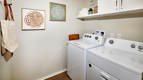 Laundry room with washer and dryer, and upper shelf and cabinet