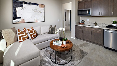 Multi-gen suite living area and kitchen area with granite countertops and dark brown cabinets
