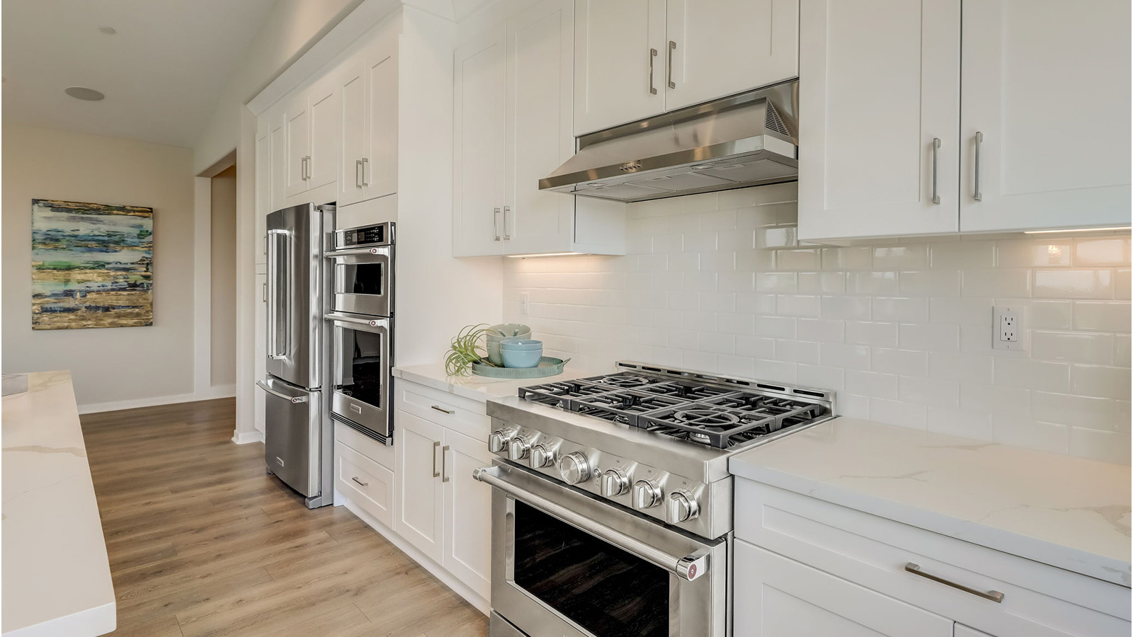 Kitchen with white cabinets quartz countertops and stainless steel appliances