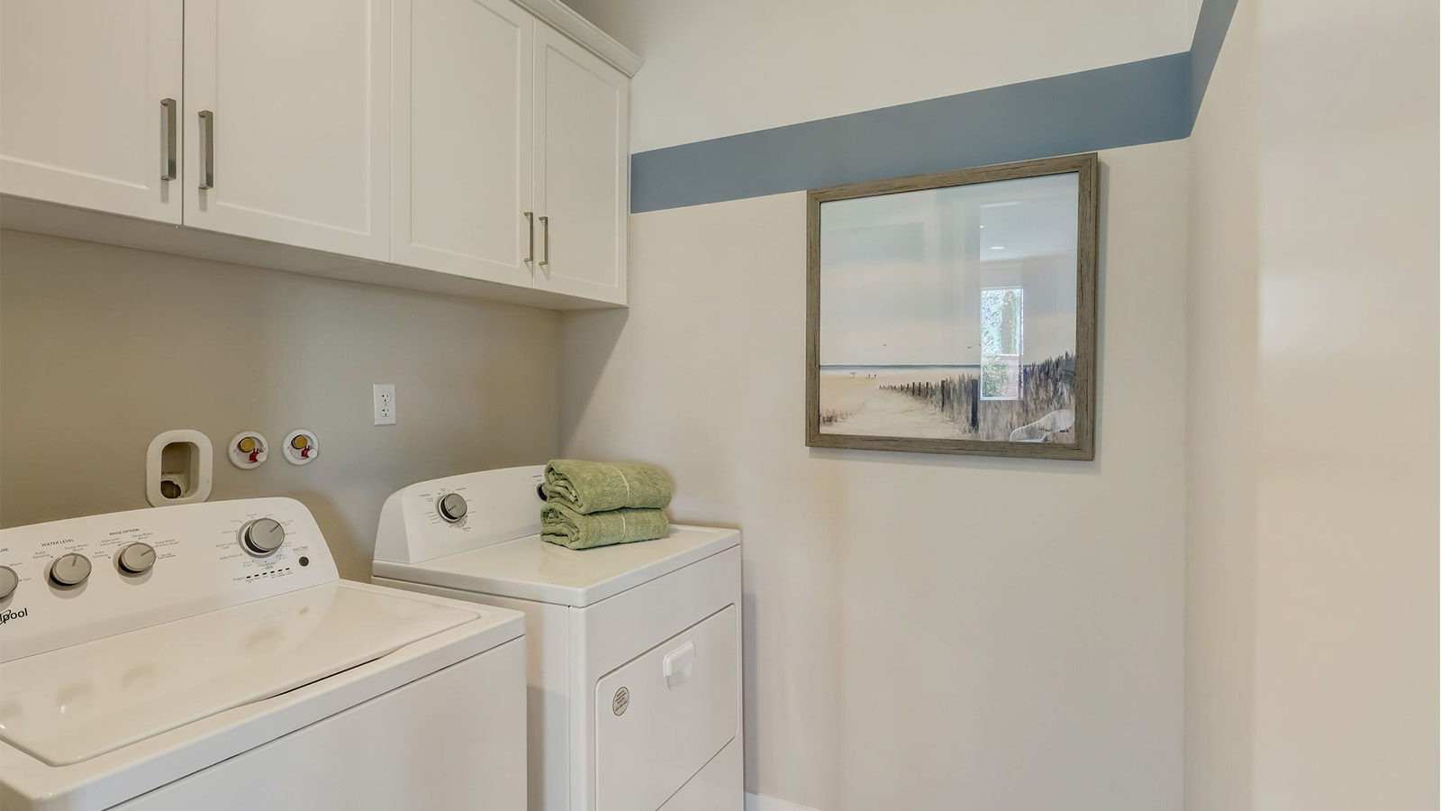 Laundry room with upper cabinets and washer and dryer