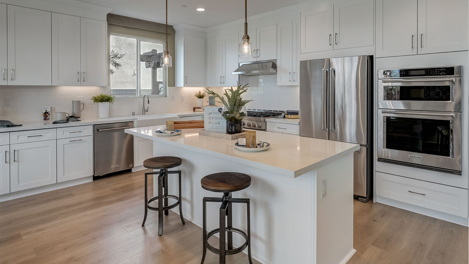Kitchen with white cabinets quartz countertops and stainless steel appliances