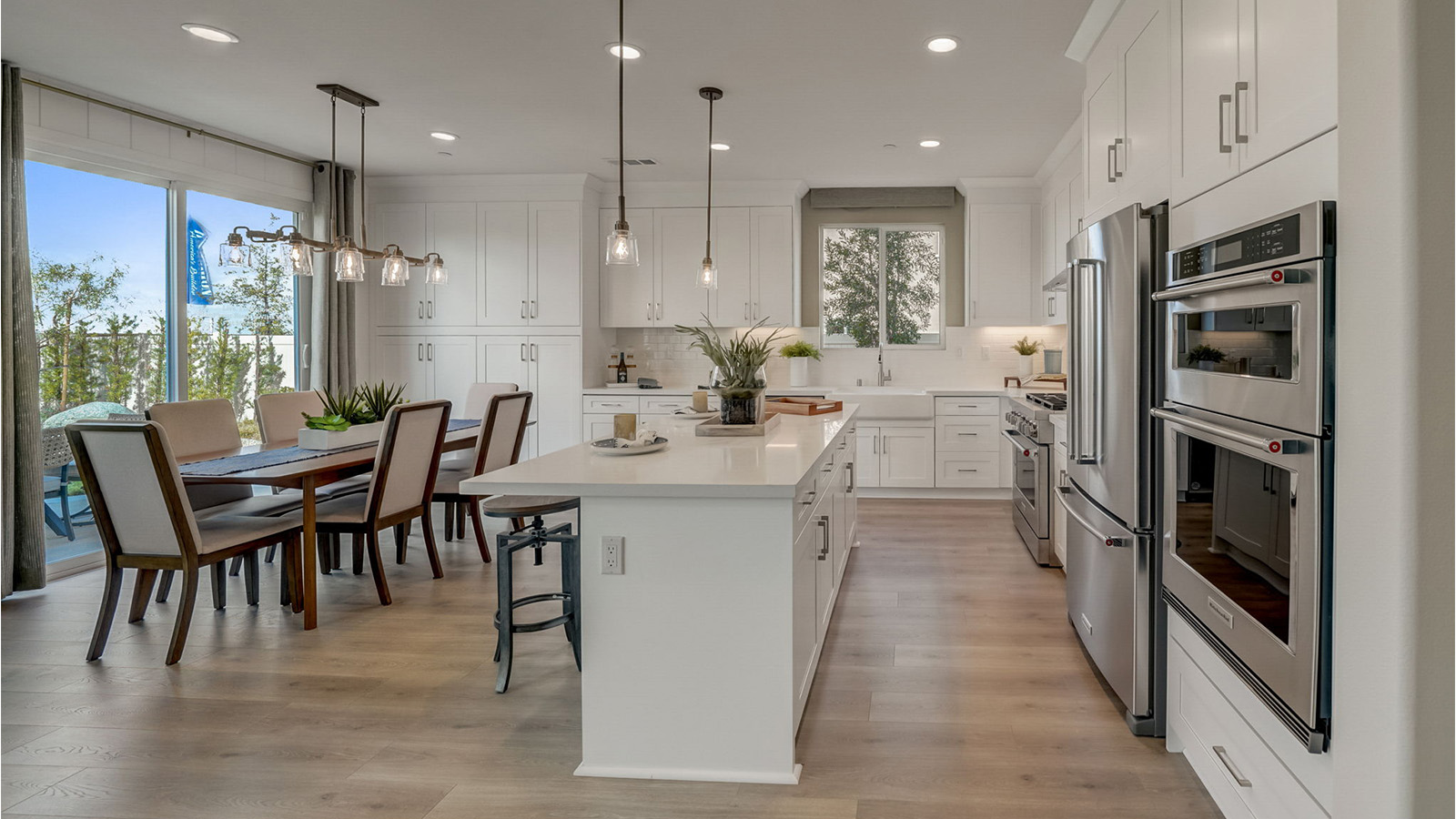 kitchen with white cabinets quartz countertops and stainless steel appliances and dining room with slider to rear yard