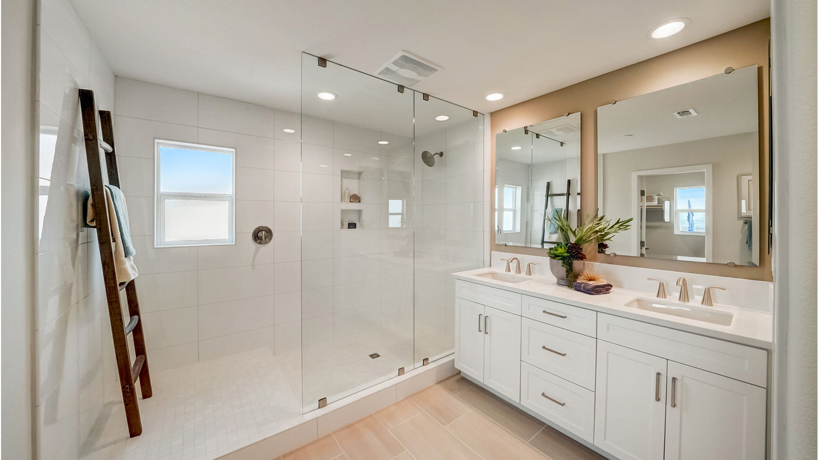Primary bathroom with walk-in shower and dual vanities