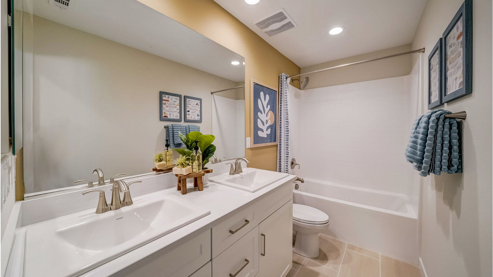 Secondary bathroom with dual vanities and tub shower