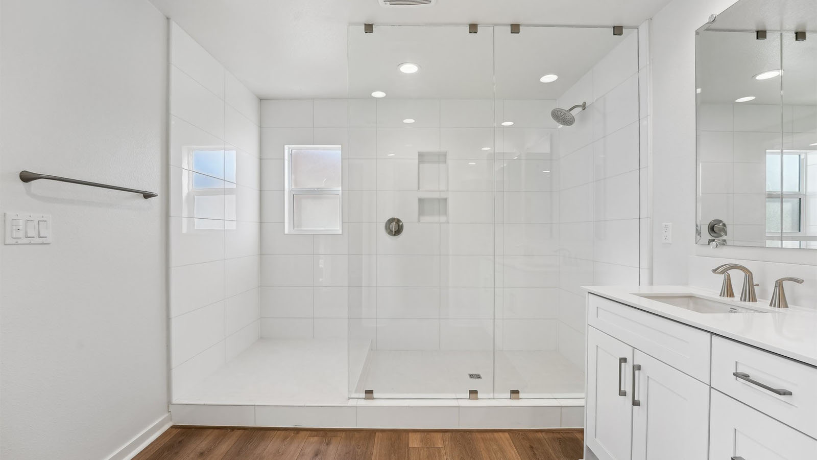 Primary bathroom with walk-in shower and dual vanities