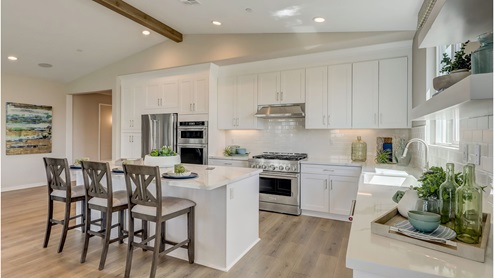 Open-concept kitchen with stainless steel appliances and quartz countertops