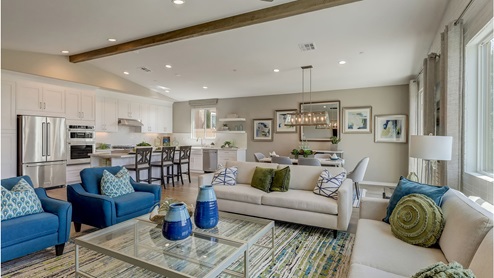 Open-concept great room, kitchen and dining area with vaulted ceiling