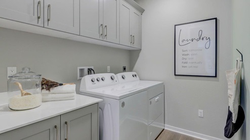 Laundry room with washer and dryer and upper cabinet