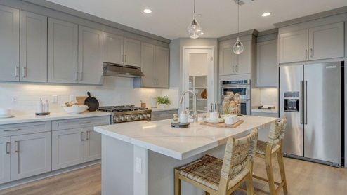 Open-concept kitchen with quartz countertops and stainless steel appliances